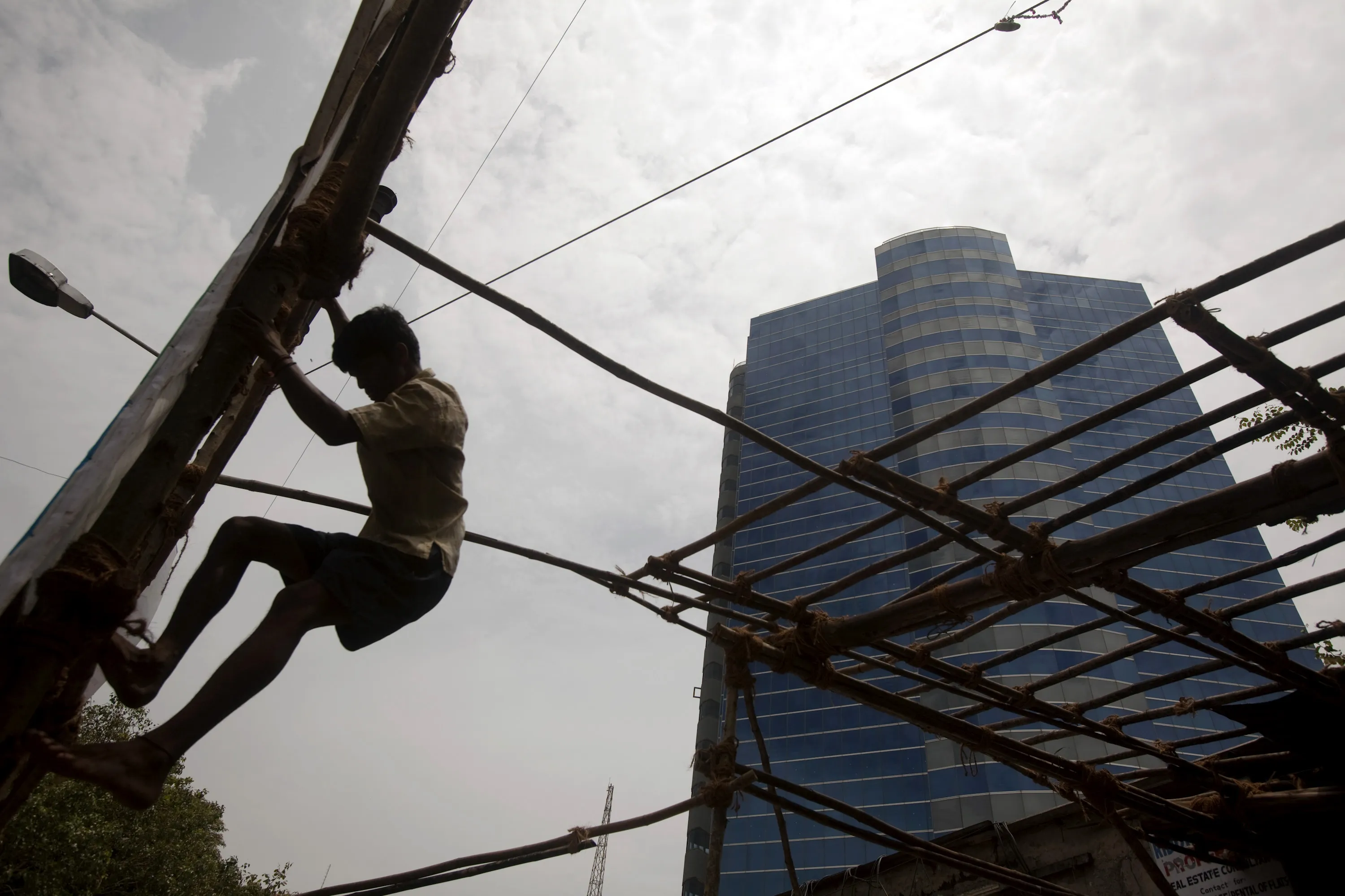 A person&nbsp;climbs wooden scaffolding near the Essar Group offices in Mumbai, India.&nbsp;