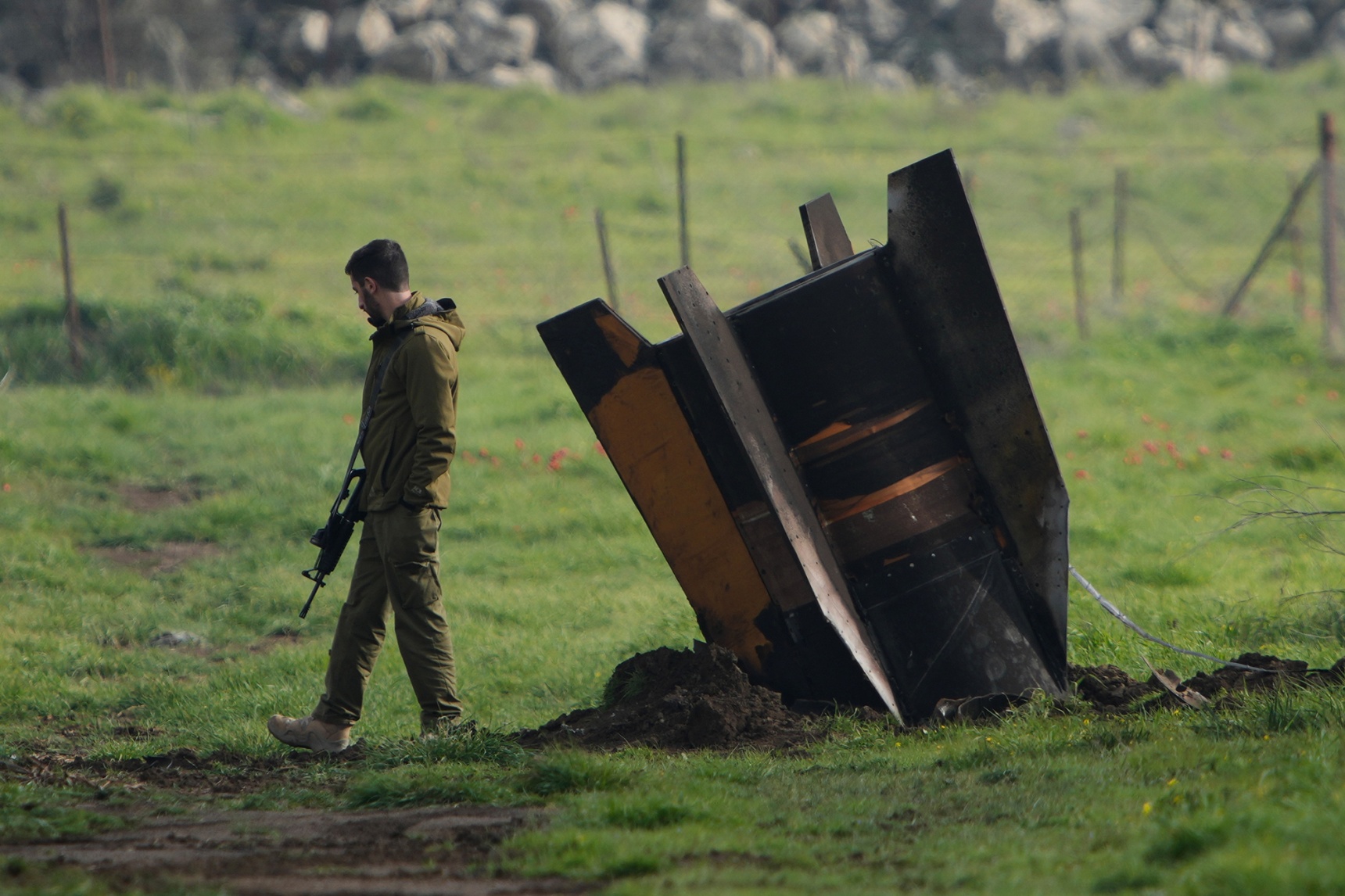 An Israeli soldier stands next to a fragment of a missile fired from Iran and intercepted by Israeli air defenses in the Golan Heights on March 19.