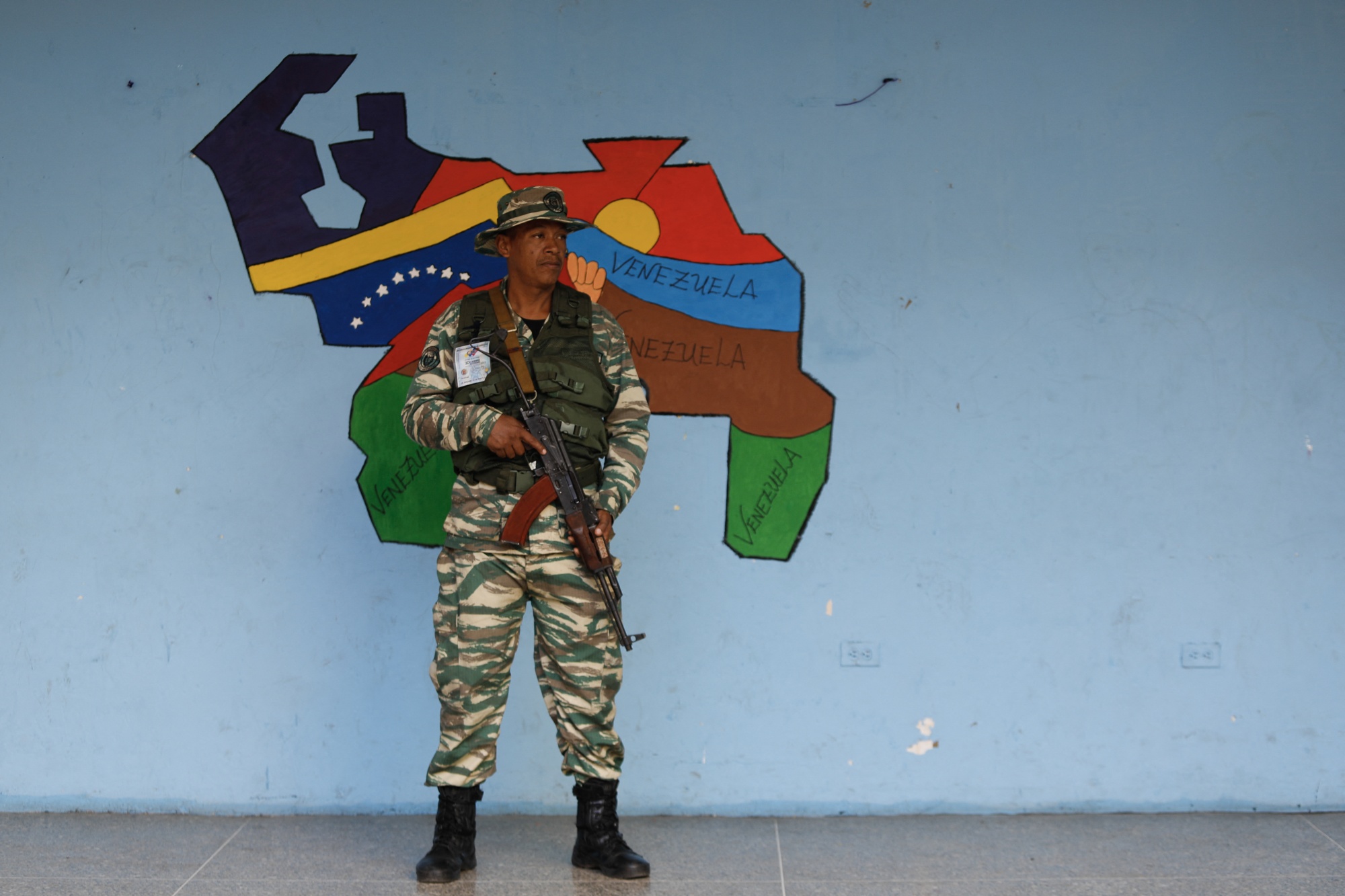 A member of a militia group stands guard at a polling station during the&nbsp;referendum on Venezuelan control&nbsp;over the Essequibo region of Guyana, in Caracas in Dec. 2023.