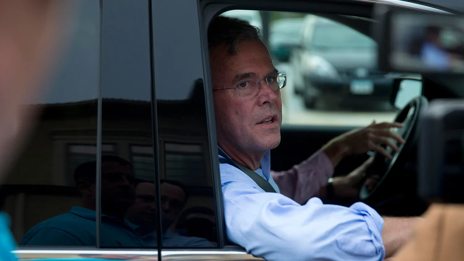 Jeb Bush, former governor of Florida and 2016 Republican presidential candidate, talks to the media from his vehicle as he leaves after speaking at the Republican Party of Polk County annual Summer Sizzle in Ankeny, Iowa, U.S., on Thursday, Aug. 13, 2015.
