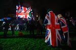 Revelers draped in a Union flags, also known as a Union Jacks, stand in the rain during the Leave Means Leave celebration at Parliament Square in London on Jan. 31.