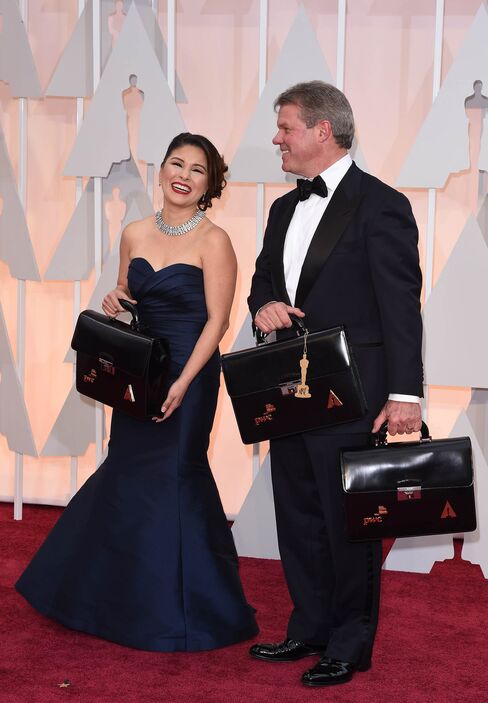 Martha Ruiz and Brian Cullinan carry the envelopes of the winners on the red carpet for the 87th Oscars on Feb. 22, 2015, in Hollywood, Calif.