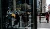 Pedestrians pass in front of a Charles Schwab Corp. office building in New York, U.S., on Thursday, April 12, 2018.