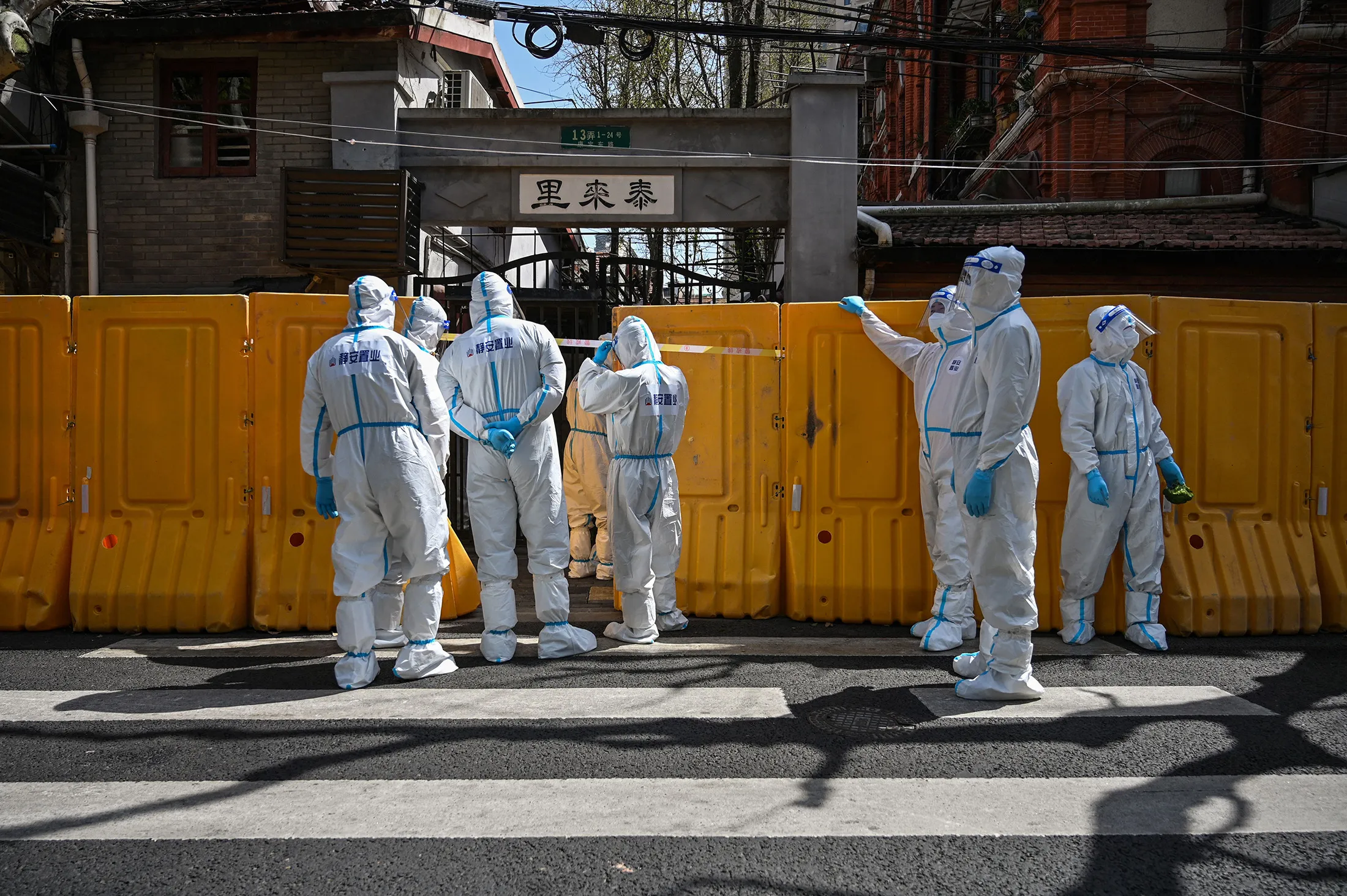 Workers from a public service organization deliver vegetables to residents of a Shanghai&nbsp;neighborhood in lockdown&nbsp;on March 29.&nbsp;