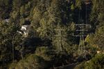 Homes nestled amongst dense brush and power transmission lines in the Oakland Hills area of Oakland, Calif.