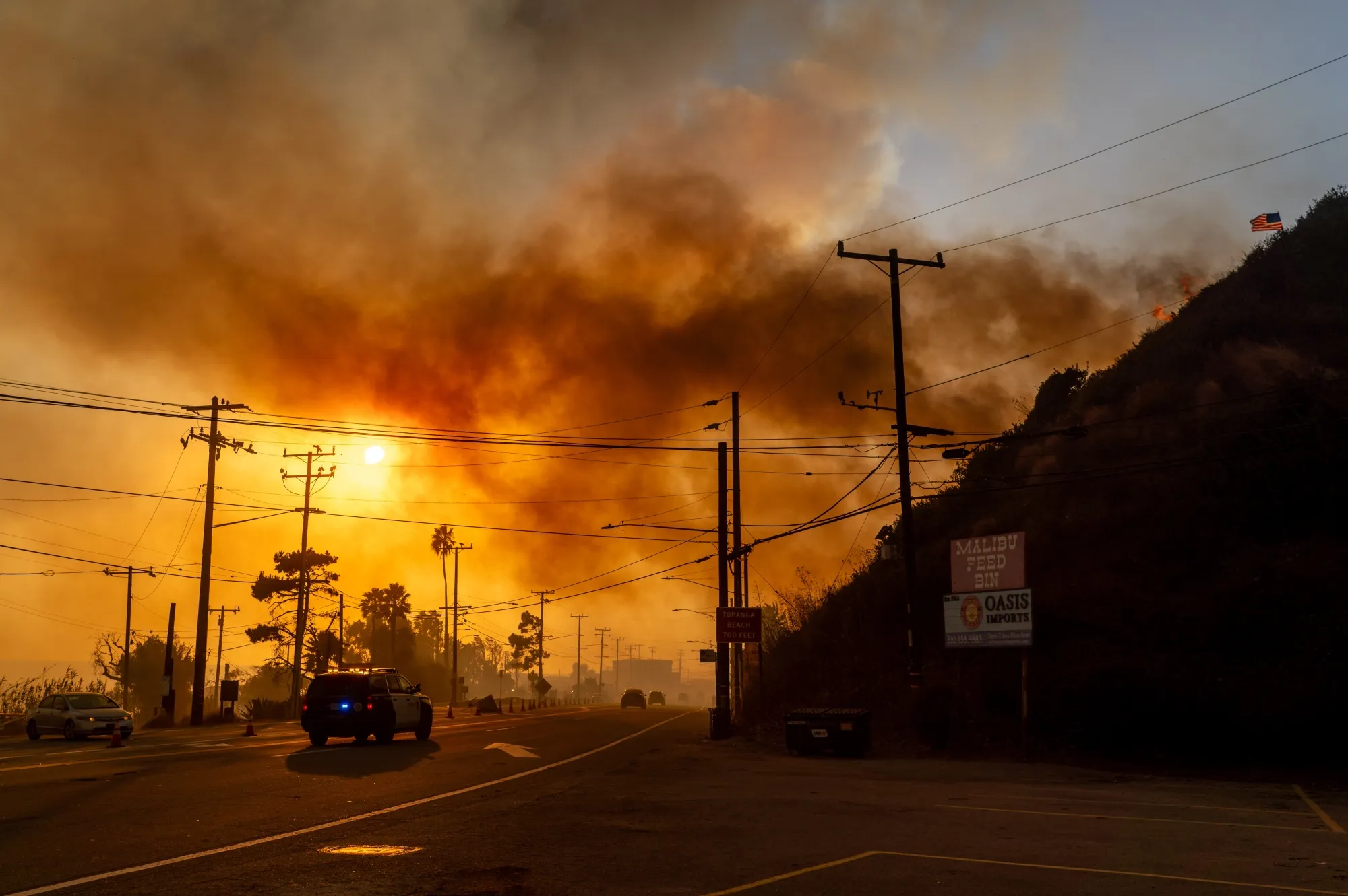 A police vehicle drives past the Palisades Fire in the Pacific Palisades neighborhood of Los Angeles on Jan. 7.