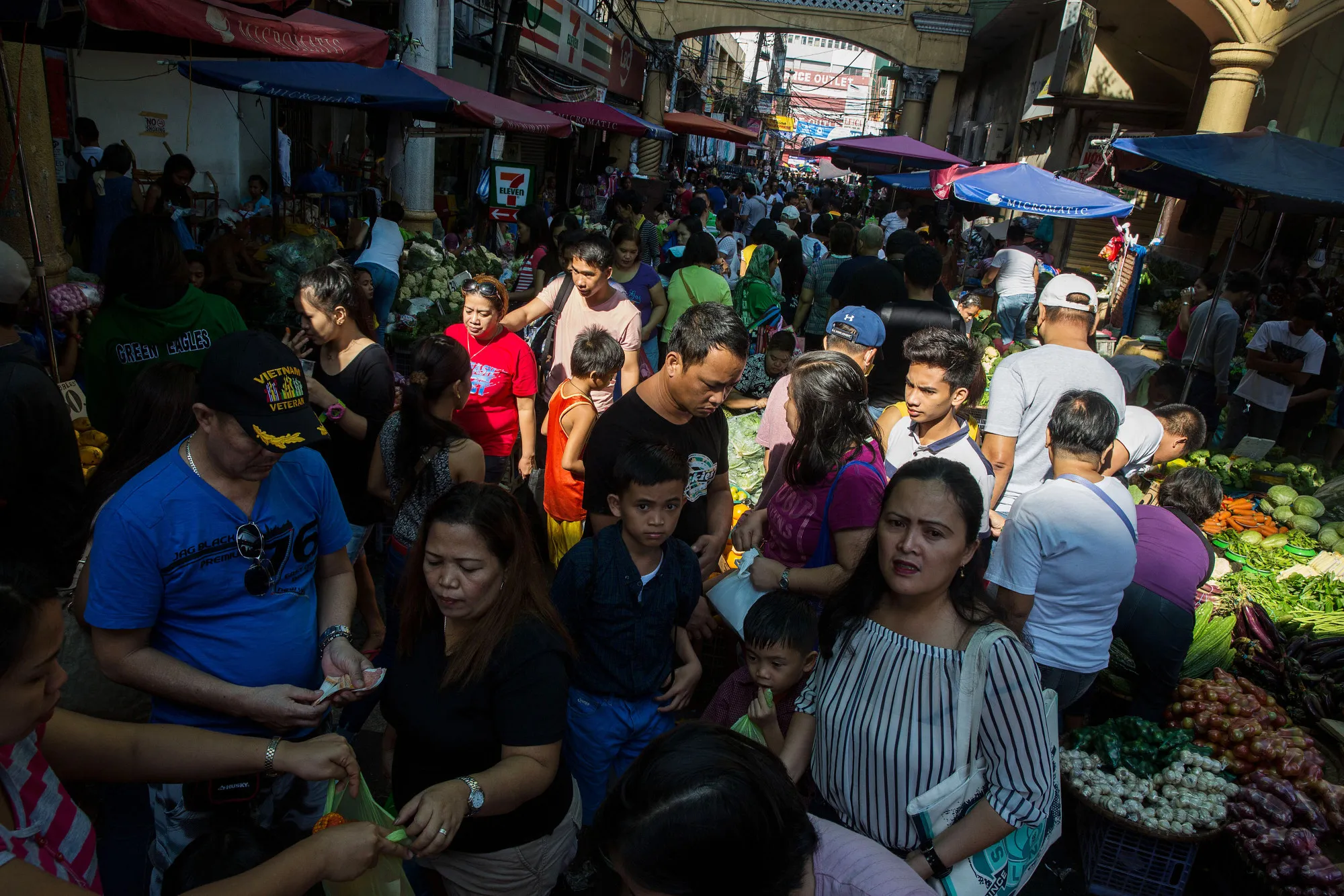Shoppers and pedestrians walk past stalls at Quiapo Market in Manila, the Philippines, on Sunday, Feb. 5, 2017. The Philippines is scheduled to release consumer price index (CPI) figures on Feb. 7.