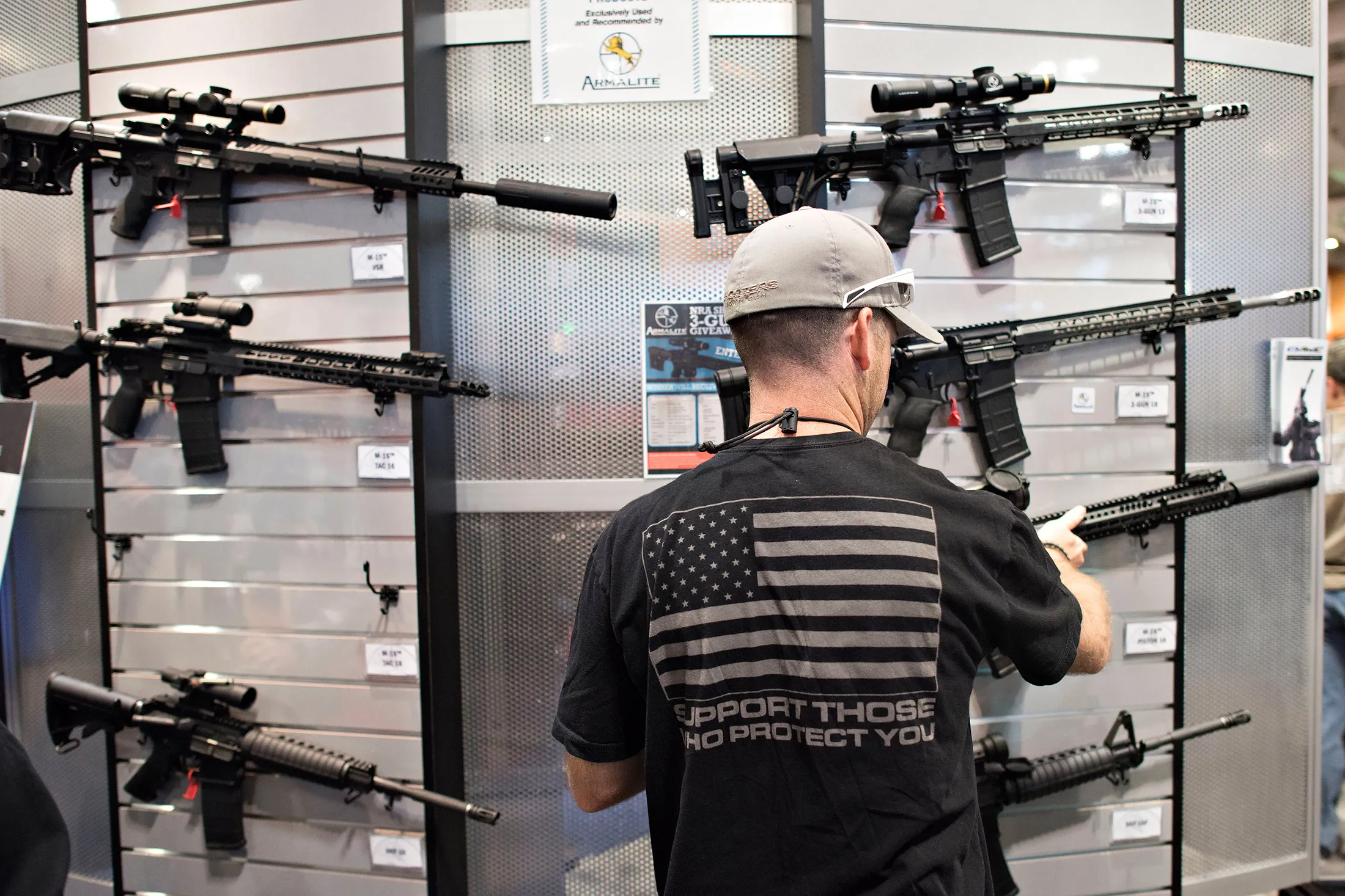 An attendee looks over rifles in the ArmaLite, Inc. booth on the exhibition floor of the 144th National Rifle Association (NRA) Annual Meetings and Exhibits at the Music City Center in Nashville, Tennessee, U.S., on Saturday, April 11, 2015
