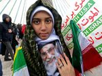 An Iranian girl poses with a potrait of Ayatollah Ali Khamenei.