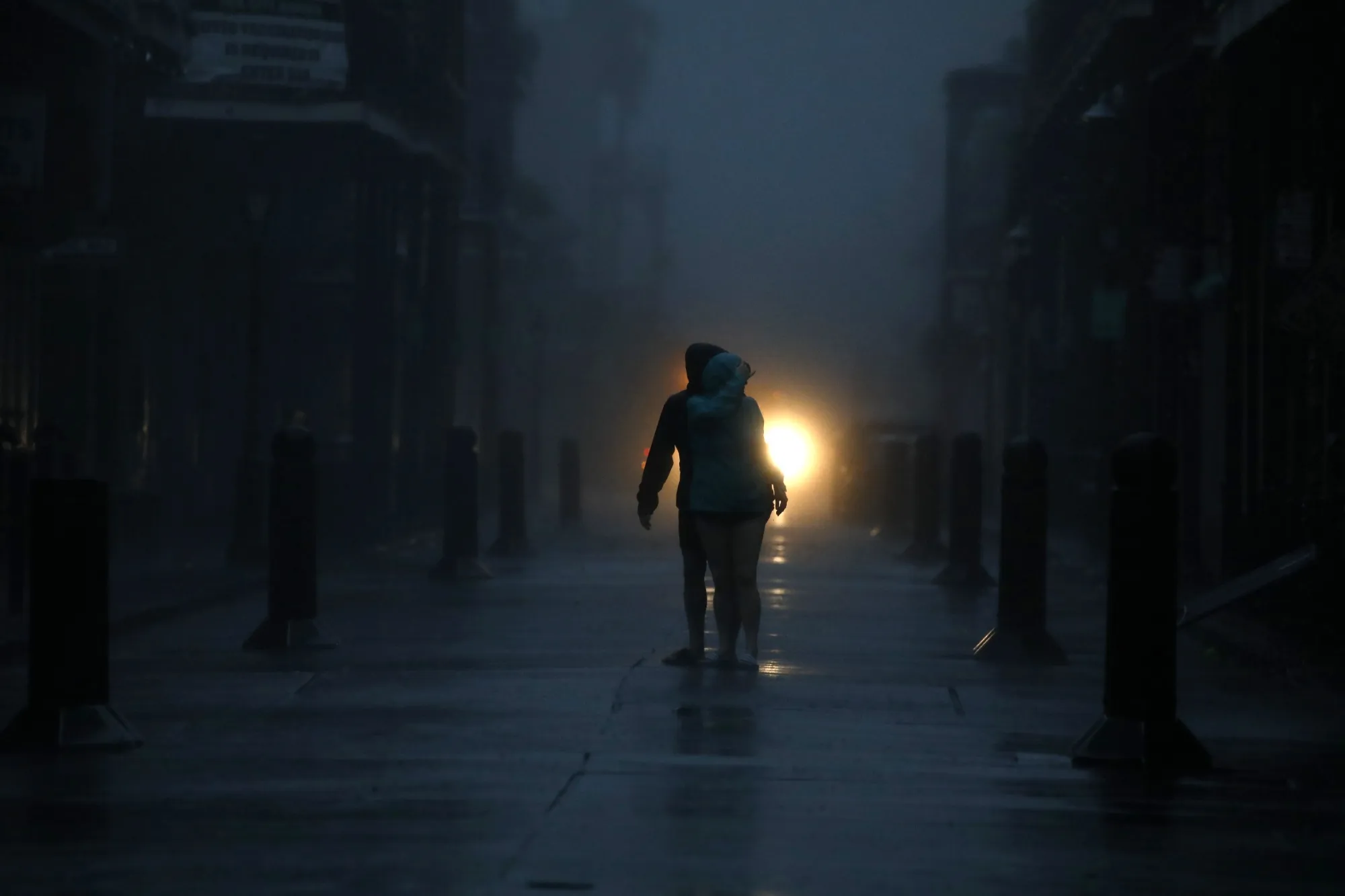 Pedestrians on Bourbon Street during a city-wide power outage caused by Hurricane Ida in New Orleans, Louisiana.