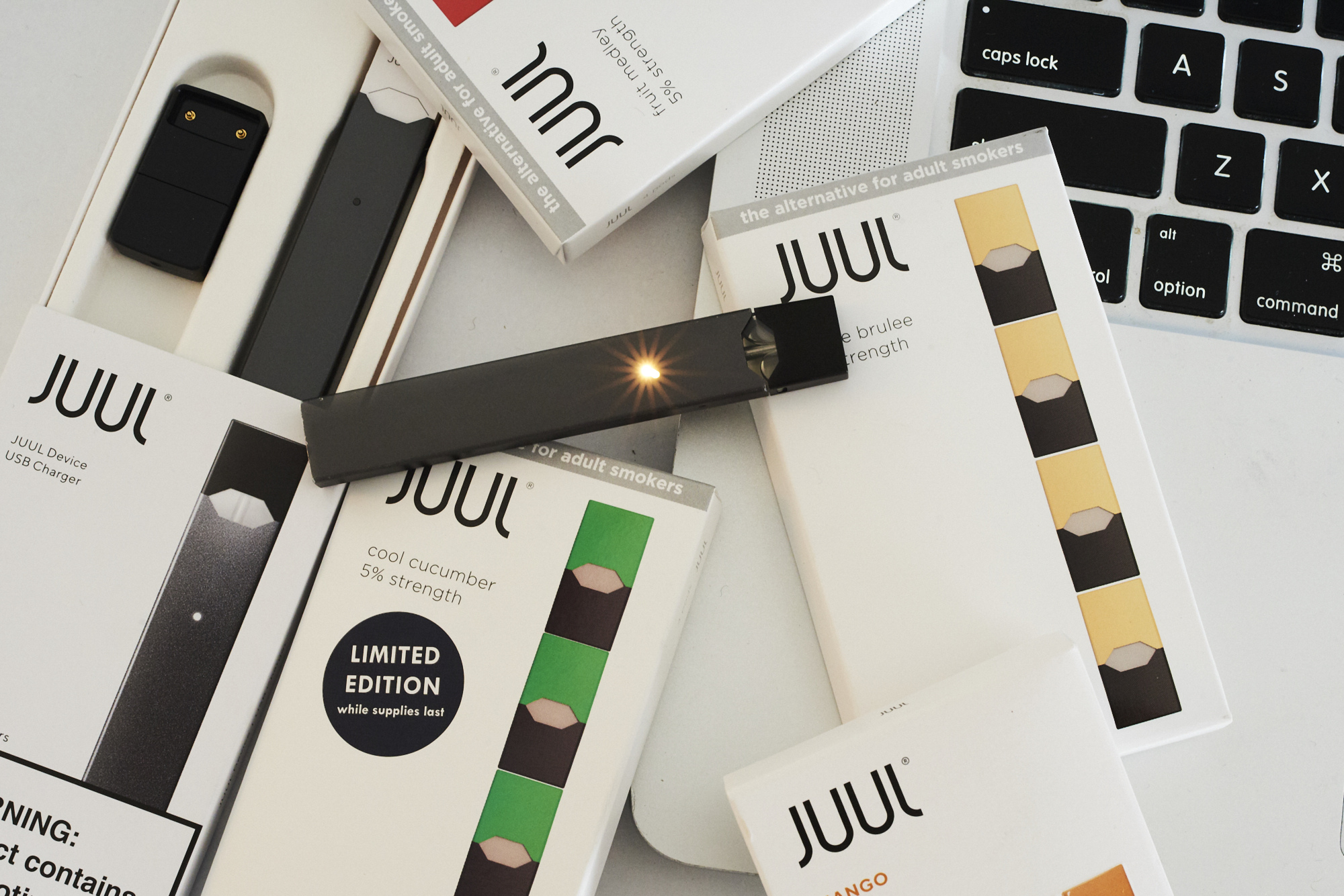A Juul Labs Inc. e-cigarette, USB charger, and flavored pods.