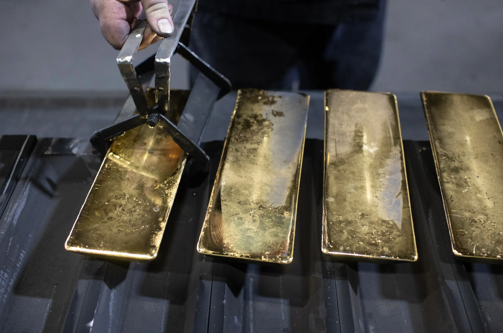 A worker removes cooled 12 kilogram gold ingots from their molds at the foundry&nbsp;in Kasimov, Russia.
