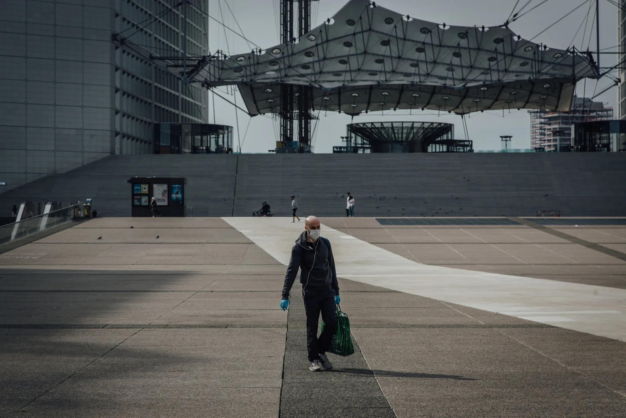 A pedestrian walks near the Grande Arche monument in the La Defense business district in Paris on April 20.