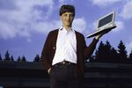 Microsoft owner and founder Bill Gates poses outdoors with Microsoft's first laptop in 1986 at the new 40-acre corporate campus in Redmond, Washington