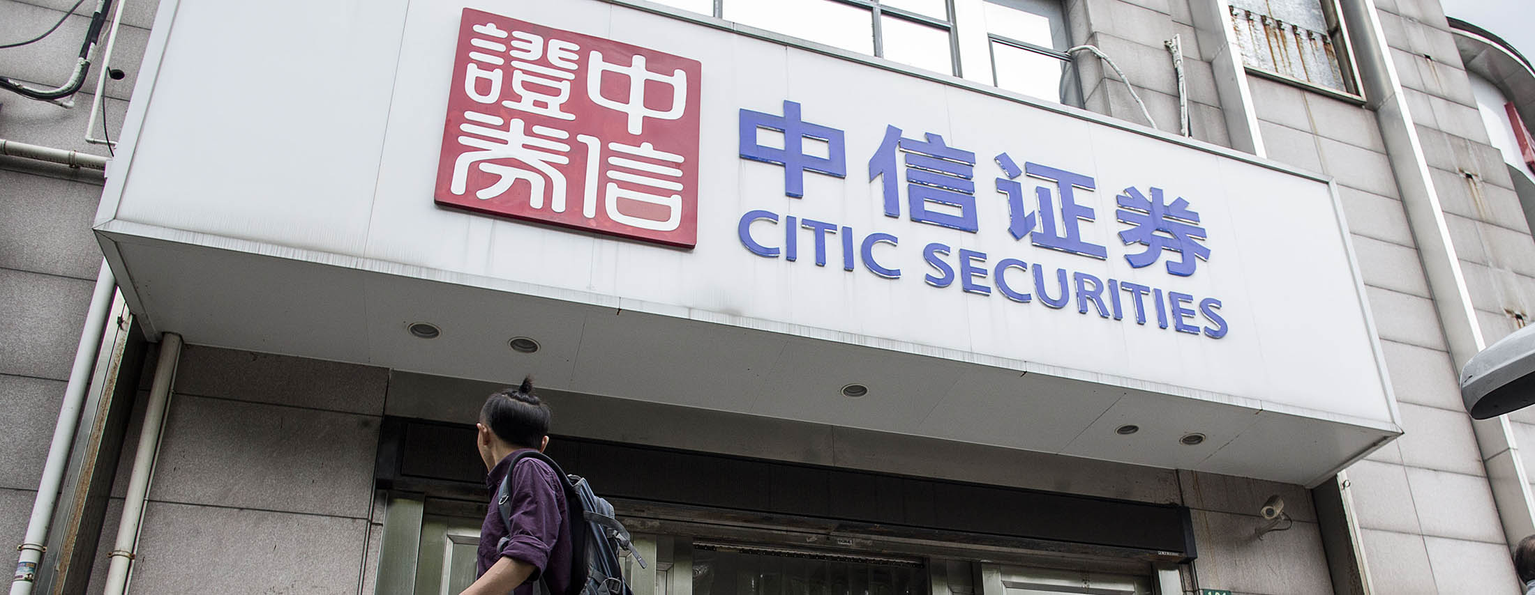 A pedestrian walks past a Citic Securities Co. branch in Shanghai, China, on Wednesday, Sept. 16, 2015. The president of China's biggest brokerage has been swept up in a widening campaign to root out financial wrongdoing and assign blame for the nation's $5 trillion stock rout.
