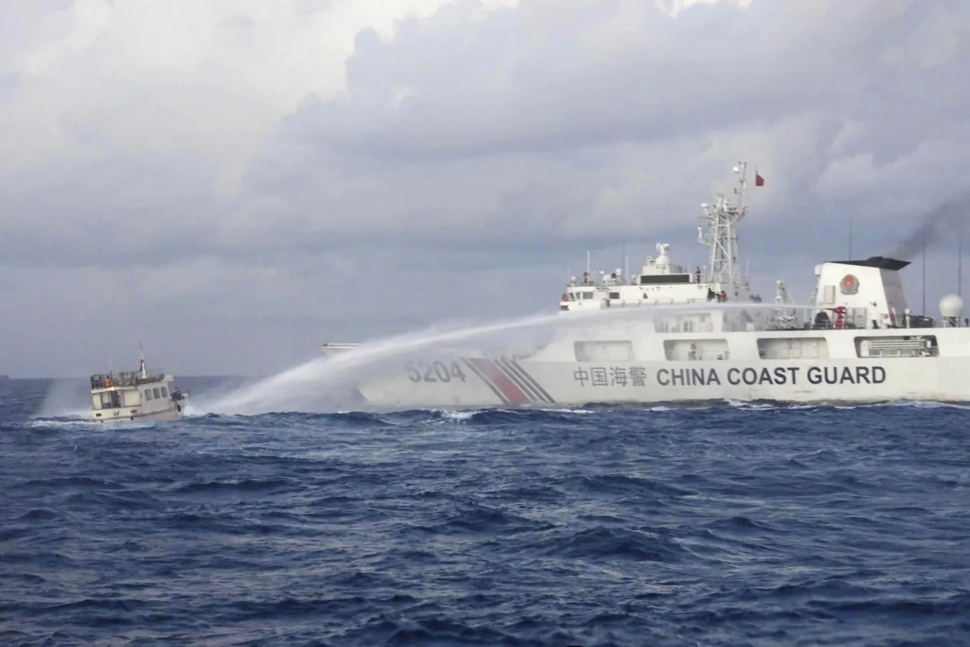A Chinese Coast Guard ship uses water cannons on the Philippine navy-operated supply ship M/L Kalayaan in the South China Sea on Dec. 10.