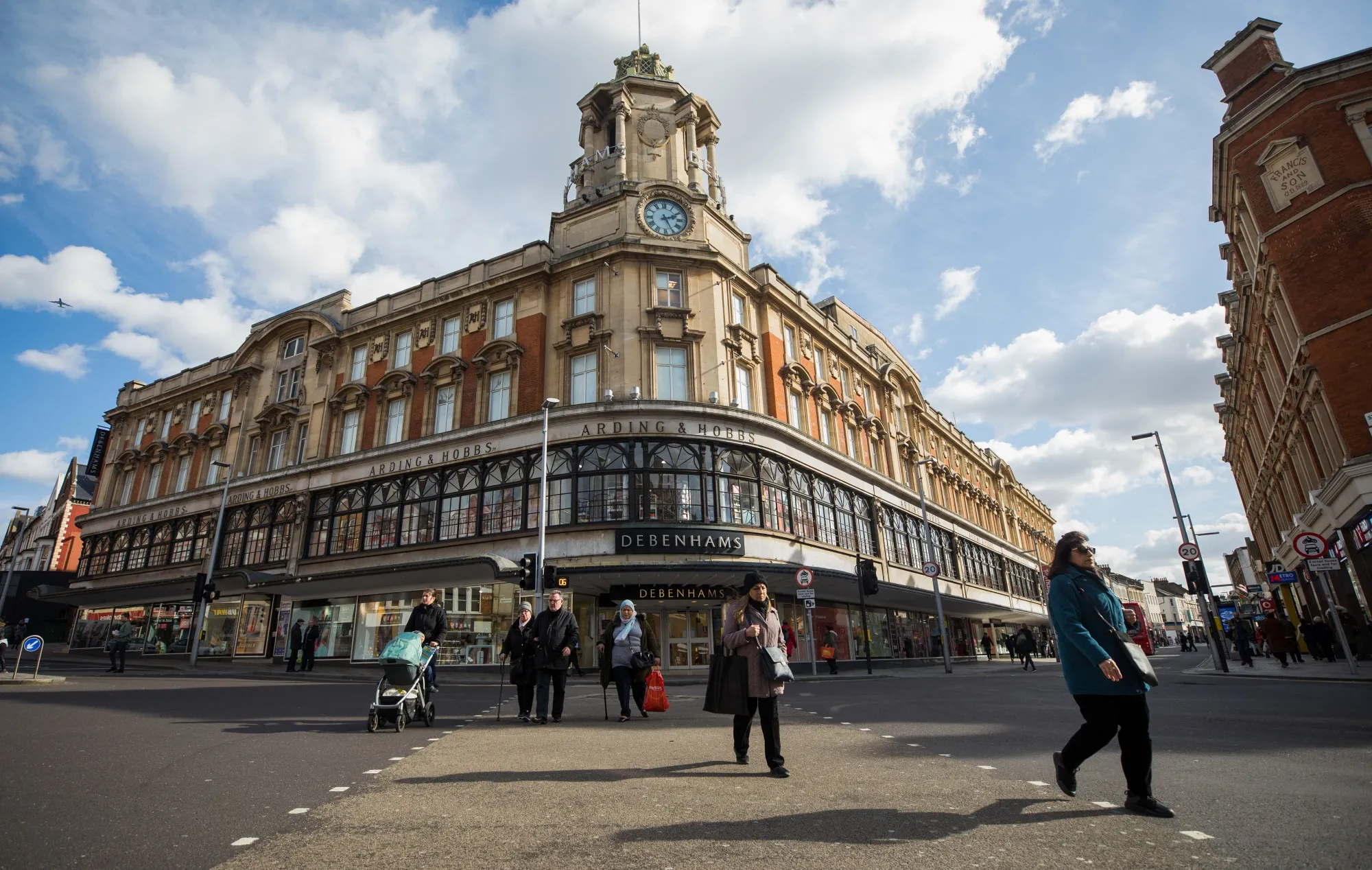 Pedestrians cross the road outside a Debenhams Plc department store in London, U.K.