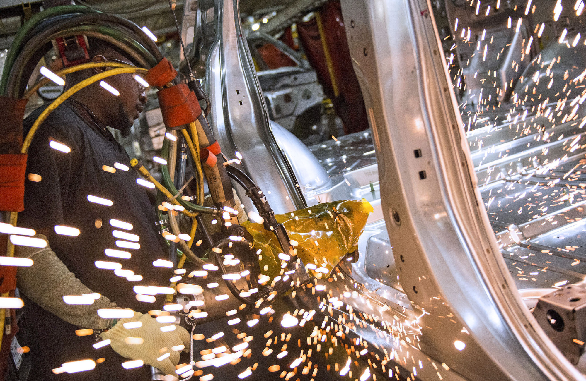 An employee welds together a frame for a sports utility vehicle during production at the General Motors Co. (GM) assembly plant in Arlington, Texas, on March 10, 2016.
