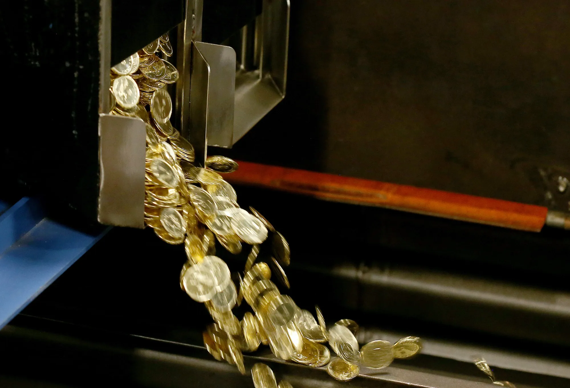 Canadian one dollar coins, also known as loonies, fall into a container at the Royal Canadian Mint.