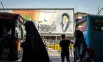 Pedestrians pass in front of mural depicting Ruhollah Khomeini, founder of the Islamic republic of Iran, in Tehran.