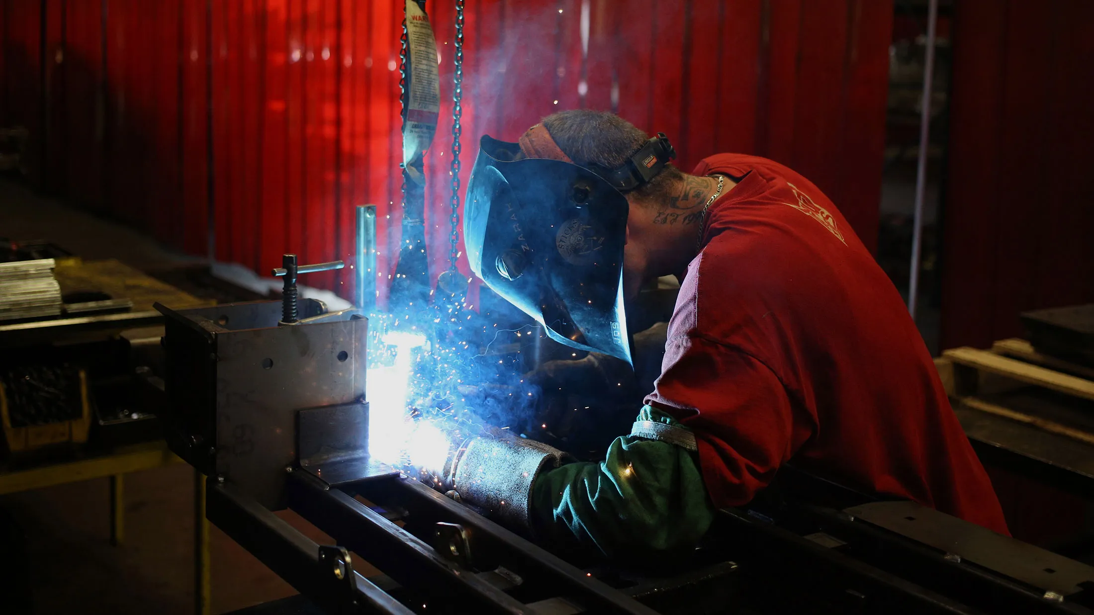A factory worker welds a lawnmower frame together on the assembly line in Coatesville, Indiana.
