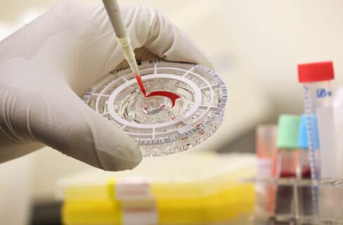 A doctor prepares a blood sample for analysis during a demonstration for the media of Ebola treatment in Berlin.