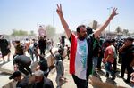 Protesters&nbsp;celebrate after bringing down concrete barriers leading to&nbsp;Baghdad's high-security Green Zone and the country's parliament, on July 30.&nbsp;