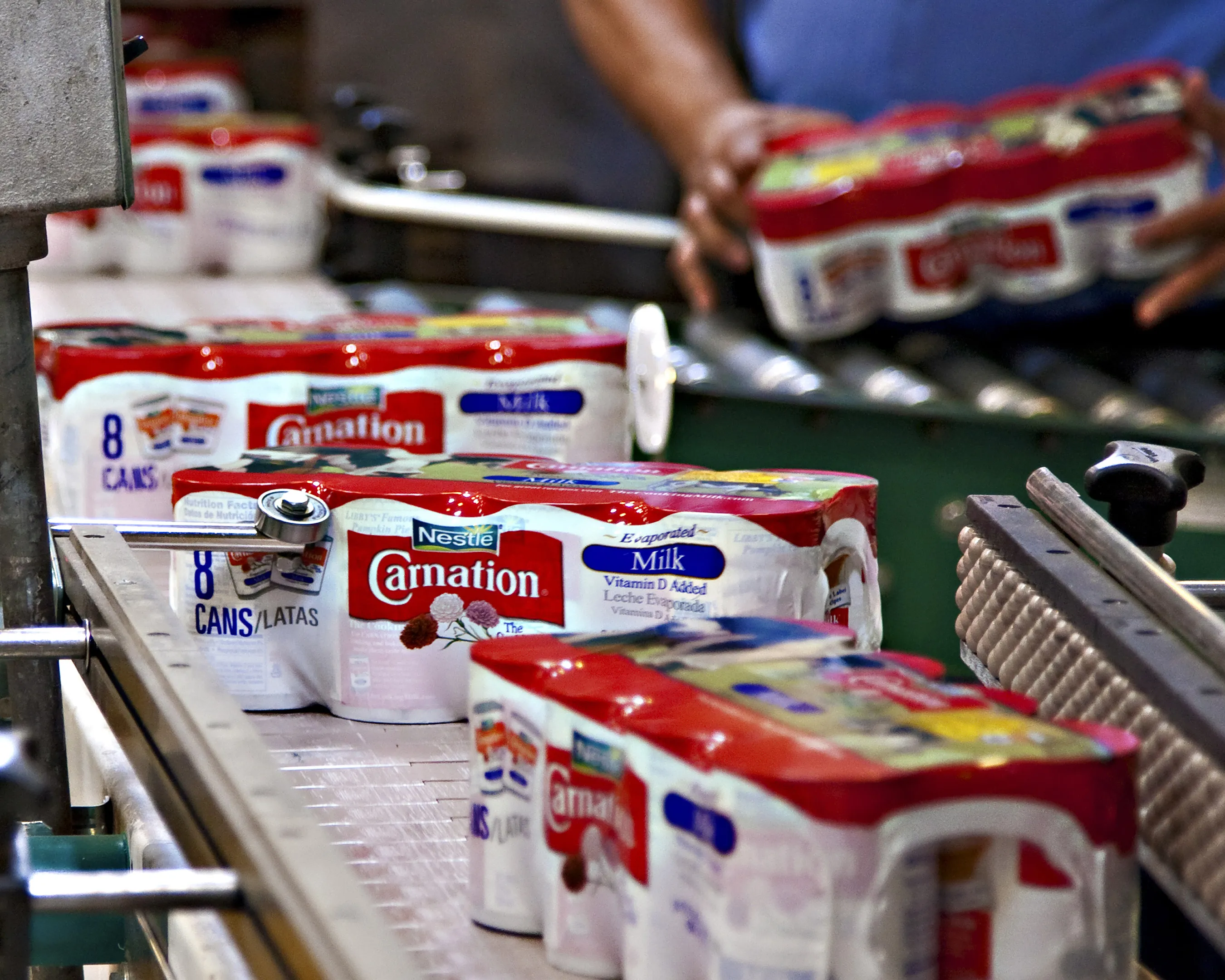 Cans of Carnation evaporated milk move along the production line at Nestle SA's factory in Modesto, California.
