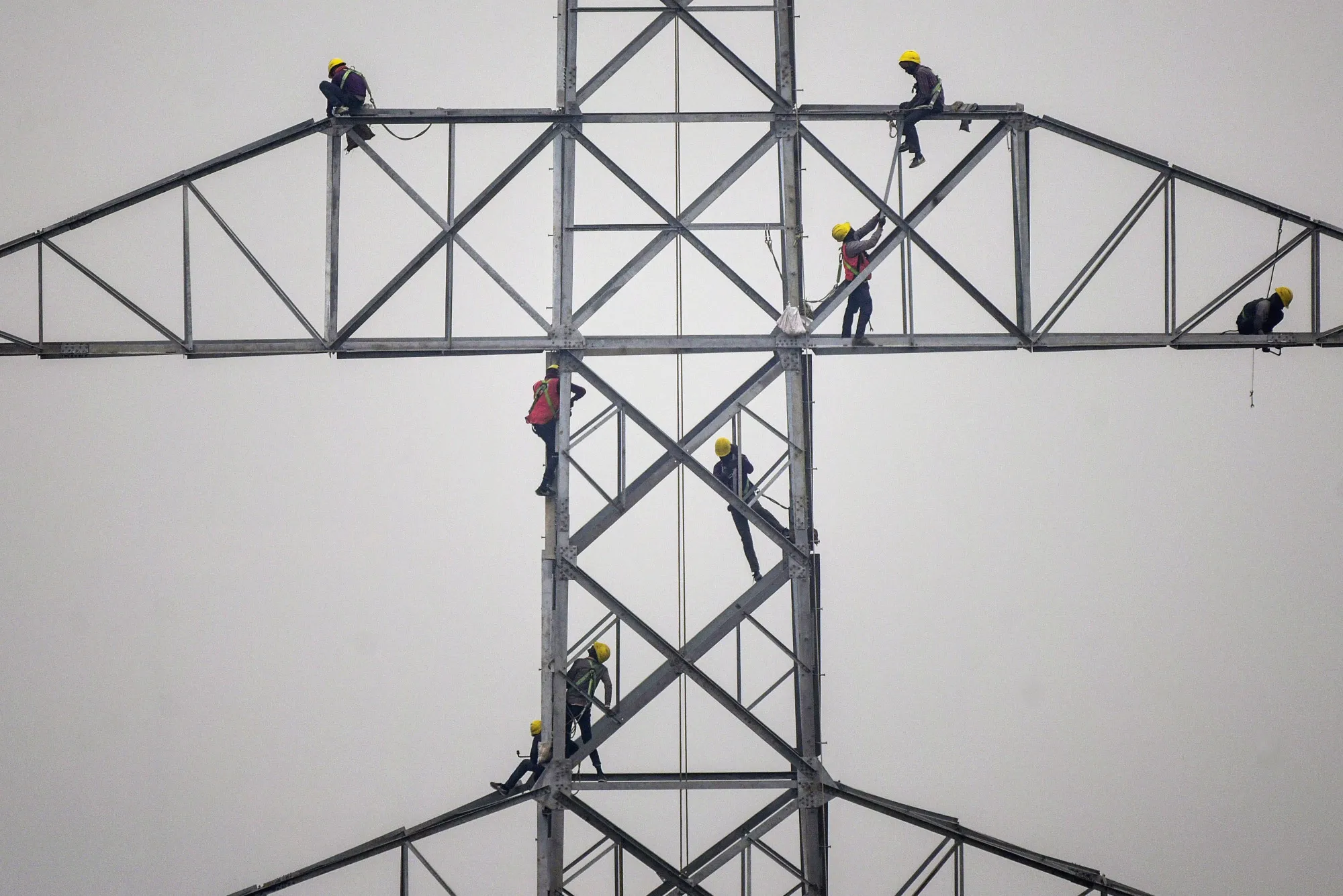 Technicians work on an unconnected transmission tower.