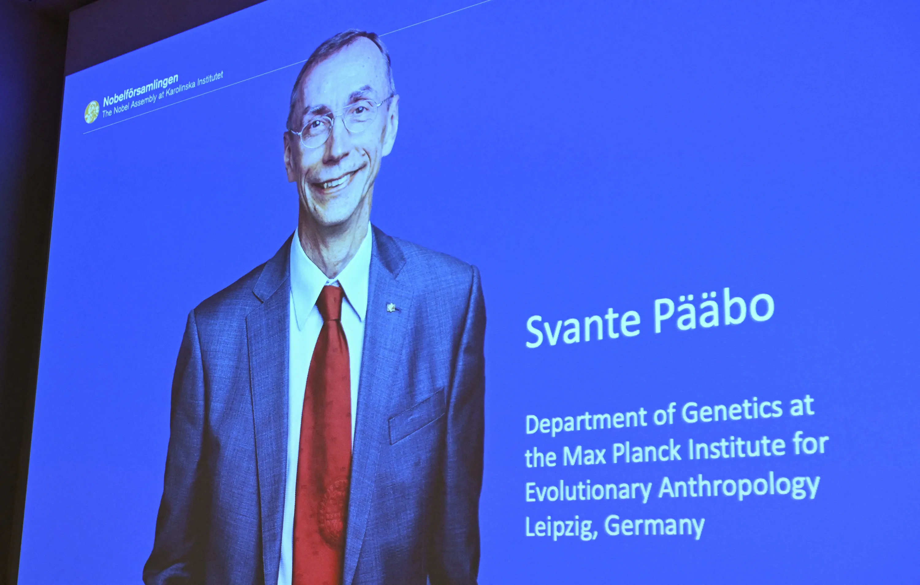 A screen shows the winner of the 2022 Nobel Prize in Physiology or Medicine Svante Paabo, during a press conference at the Karolinska Institute in Stockholm, Sweden, on Oct. 3.