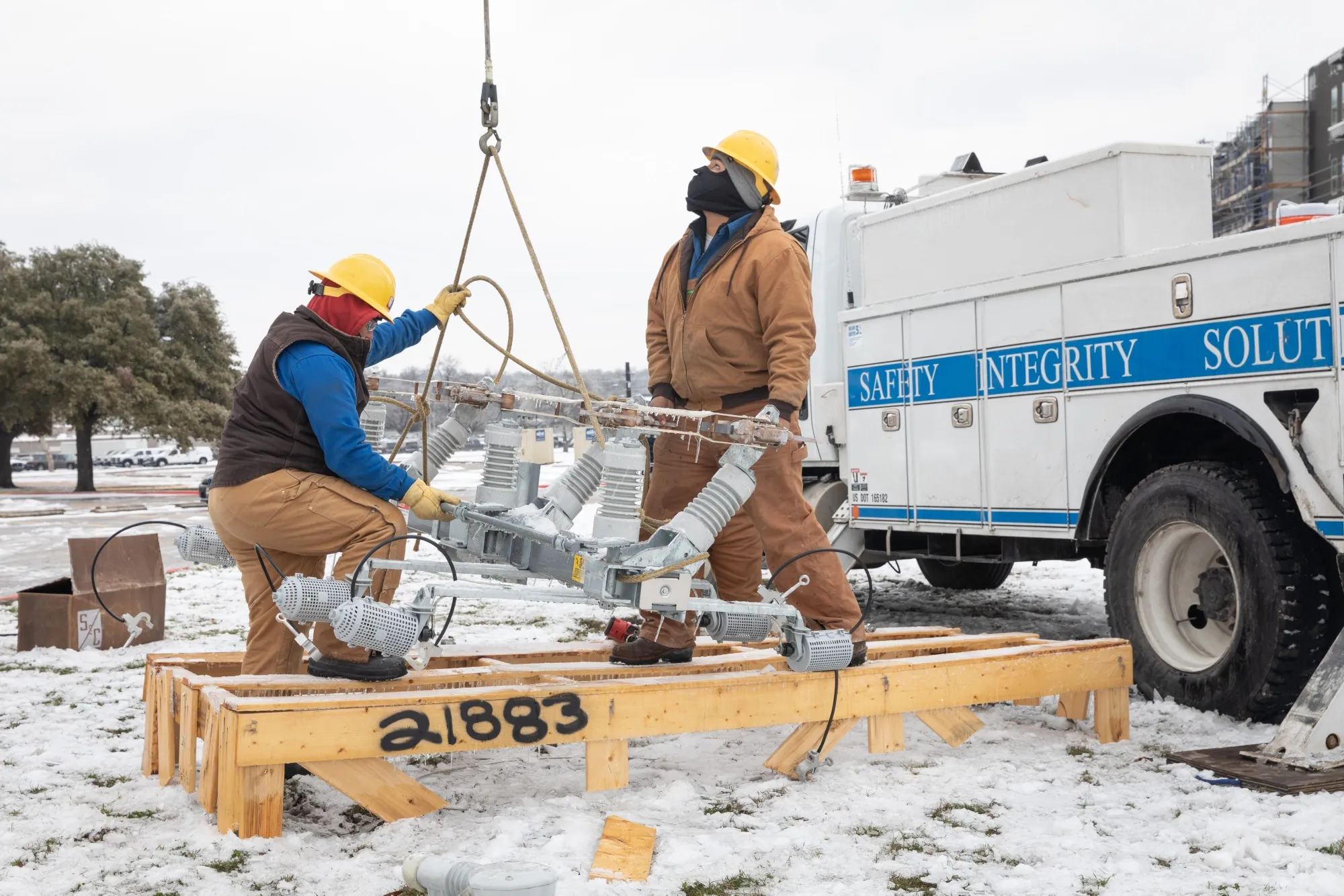 Workers repair a power line in Austin, on Feb. 18.