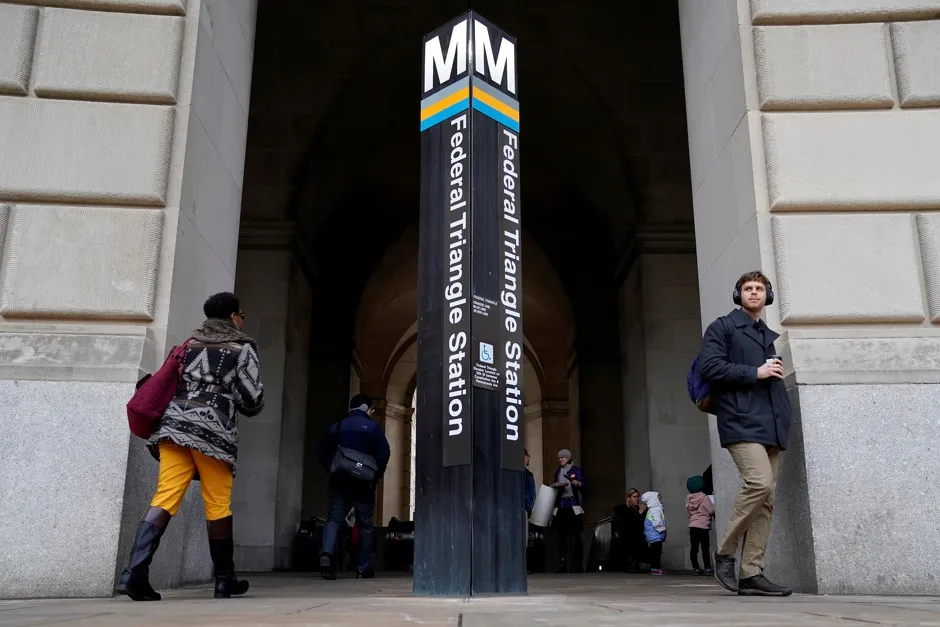 Commuters enter and exit the Federal Triangle Metro station in Washington, D.C, January 28, 2019.