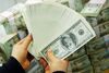 SEOUL, SOUTH KOREA - FEBRUARY 22: A South Korean banker carries US dollar bank notes at the Korea Exchange bank on February 22, 2005 in Seoul, South Korea. The South Korean won jumped to its highest intraday level in more than seven years in domestic trade on Tuesday, boosted by strong foreign equity buying and exporter deals. (Photo by Chung Sung-Jun/Getty Images)