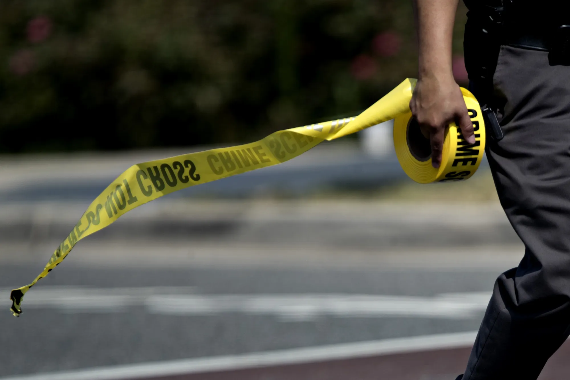 A police office carries crime scene tape&nbsp;in Alexandria, Virginia.