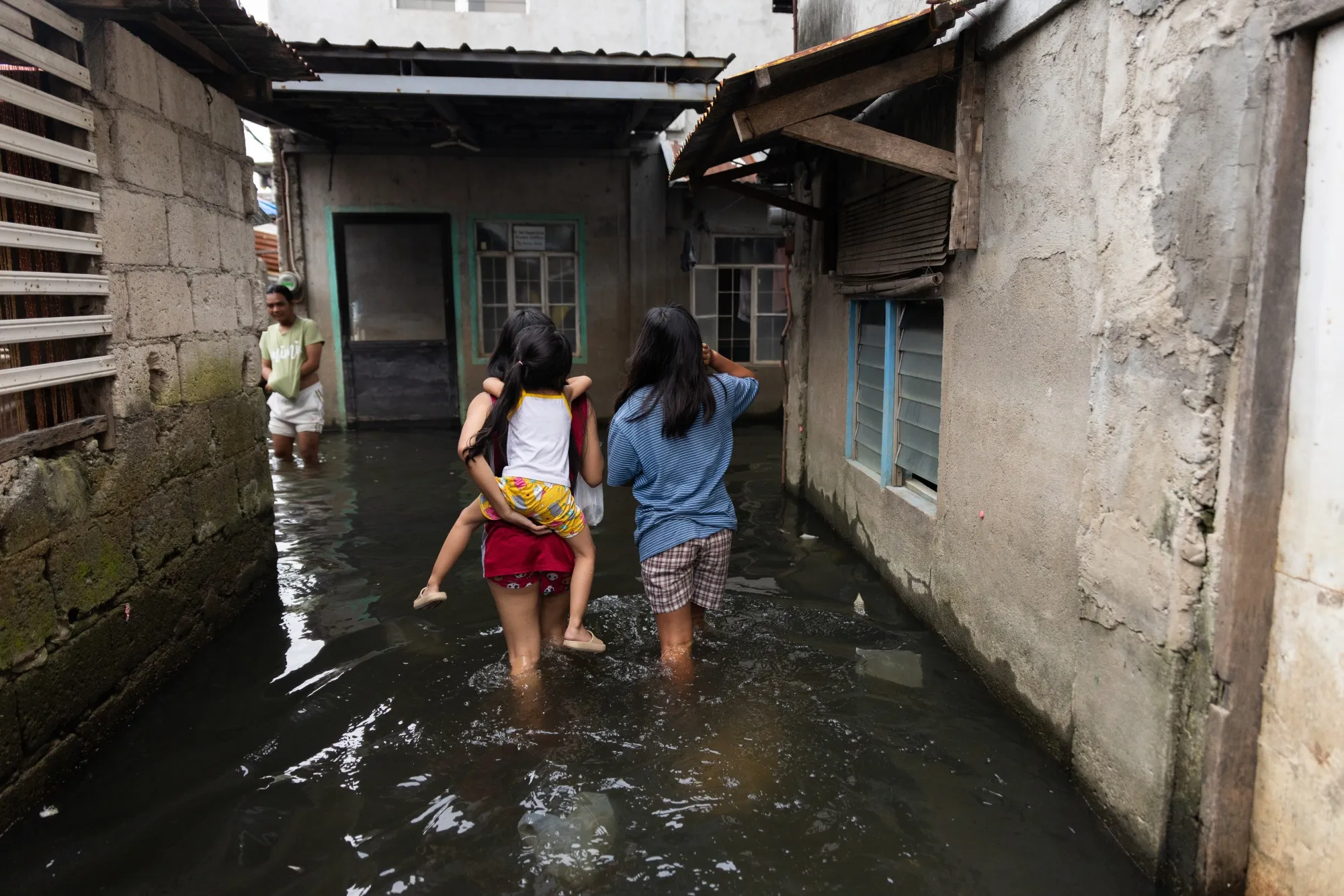 Residents navigate through a flooded road in Barangay Frances in Calumpit, Bulacan, the Philippines on Saturday, Dec. 6 2025.