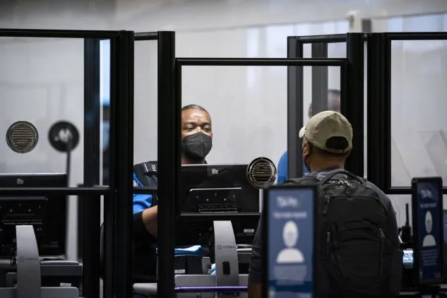 A Transportation Security Administration agent screens a traveler at Raleigh-Durham International Airport in Morrisville, N.C., on Jan. 20, 2022. 