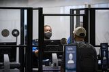 A Transportation Security Administration agent screens a traveler at Raleigh-Durham International Airport in Morrisville, N.C., on Jan. 20, 2022.