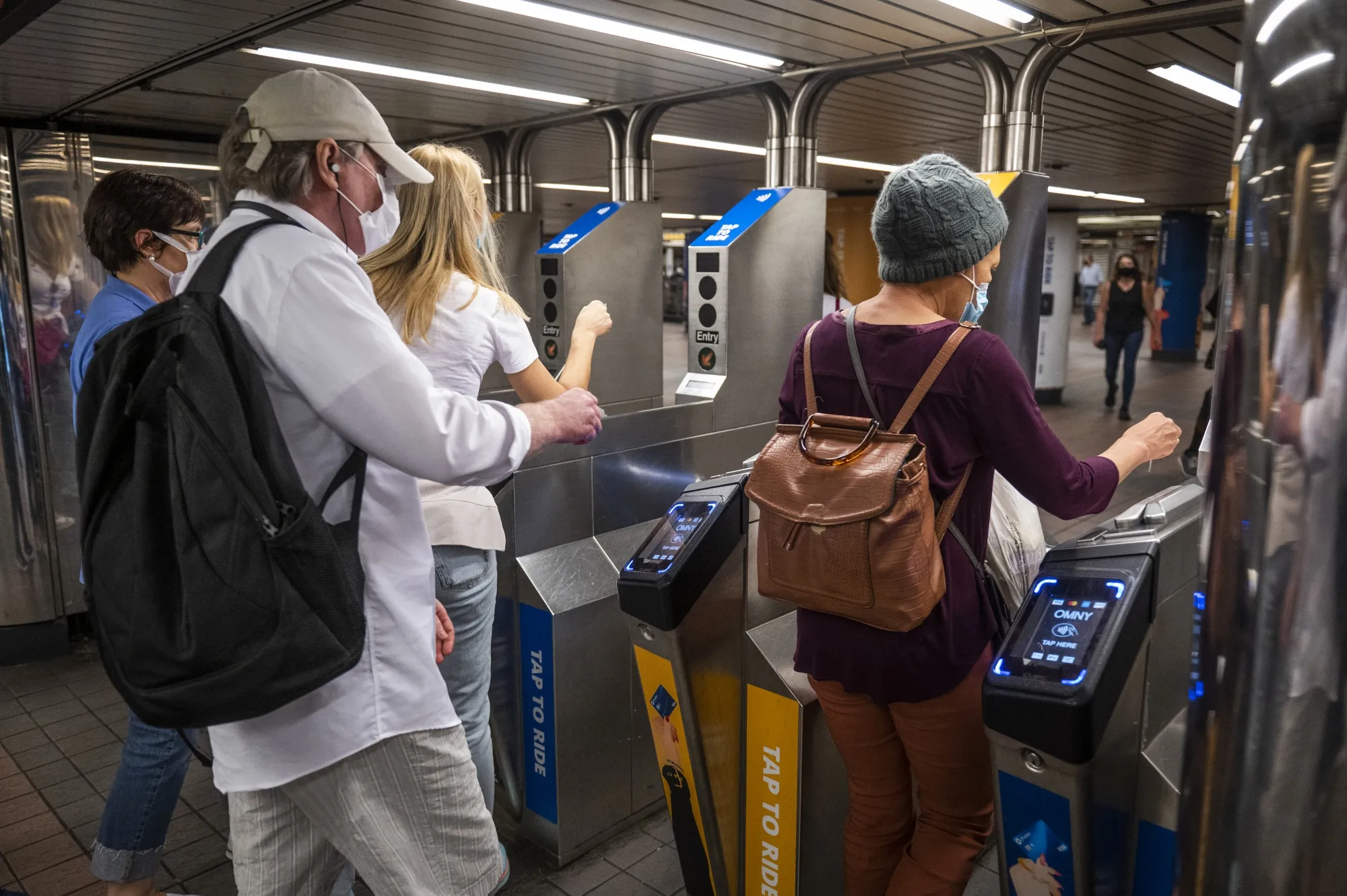 Commuters swipe MetroCards to enter a subway station in New York.