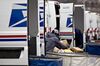 A letter carrier prepares a vehicle for deliveries at the United States Postal Service.