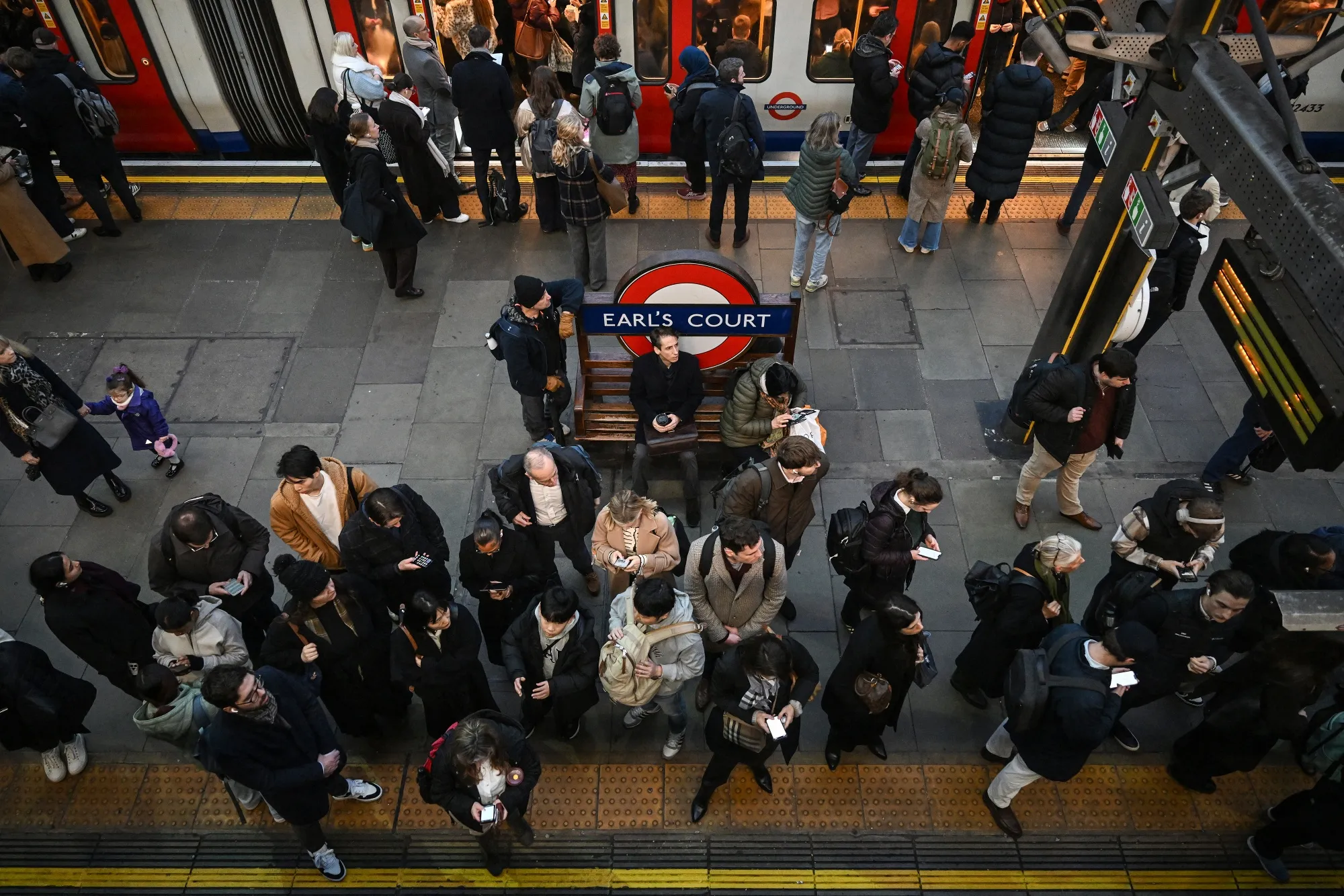 Commuters exit and board a train on the platform at Earl’s Court Tube station in London in January.