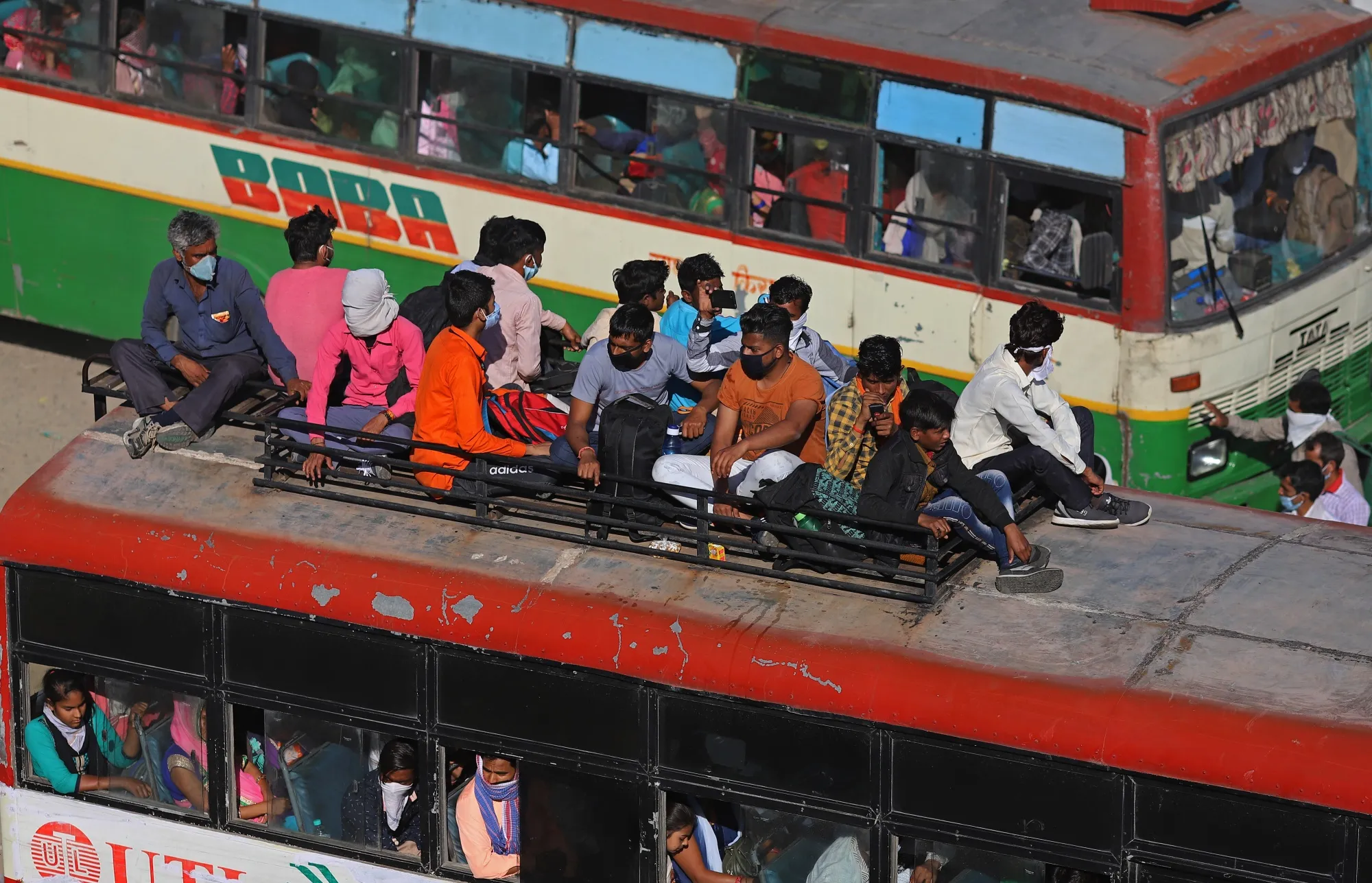 Migrant workers and their families board buses during a lockdown in New Delhi, India, on March 28.