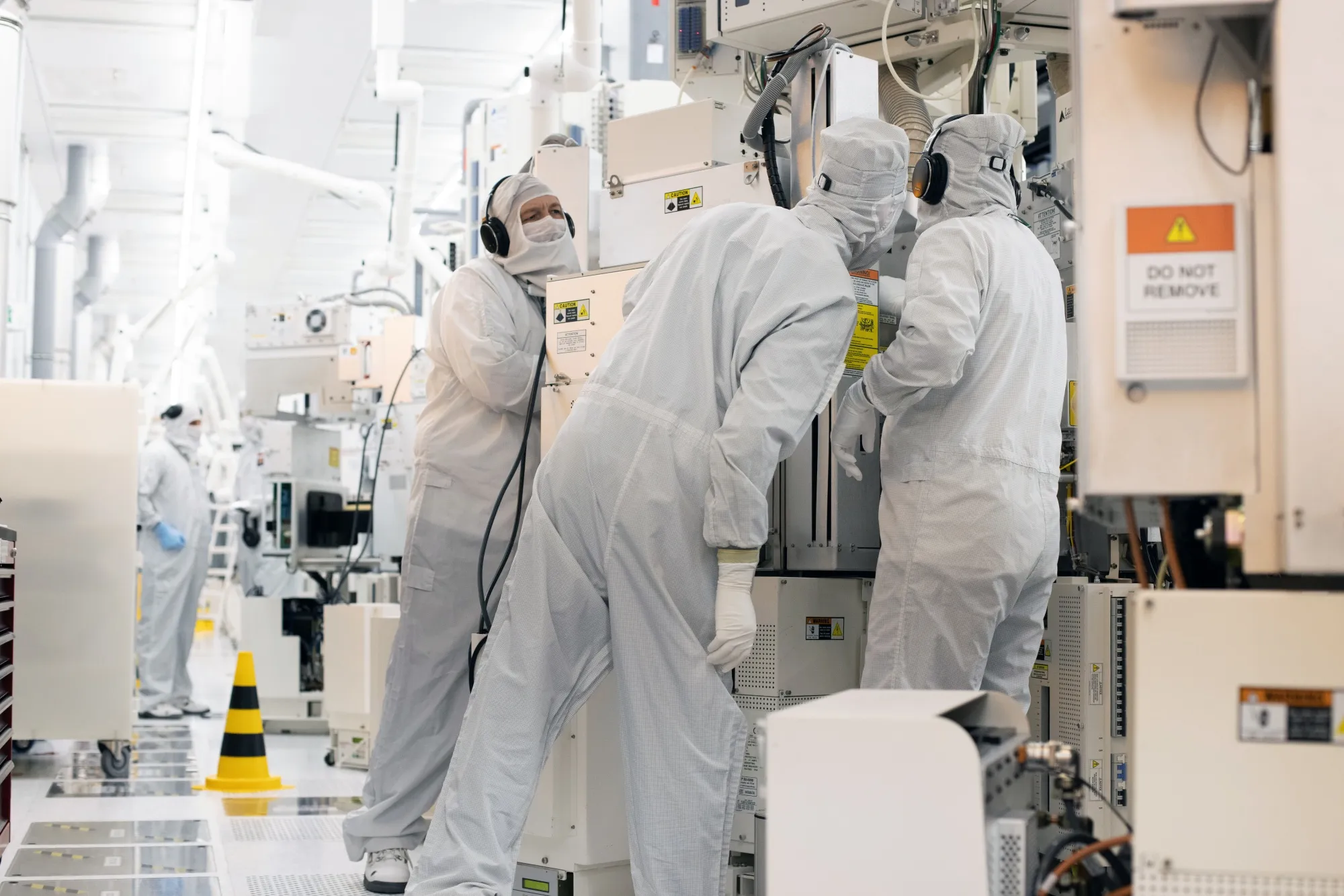 Technicians perform production control tasks in a cleanroom at a semiconductor fabrication plant in Dresden, Germany.