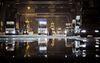 Trucks wait in line to unload their containers onto a container ship docked at the the Xiamen Songyu Container Terminal at night in Xiamen, China.