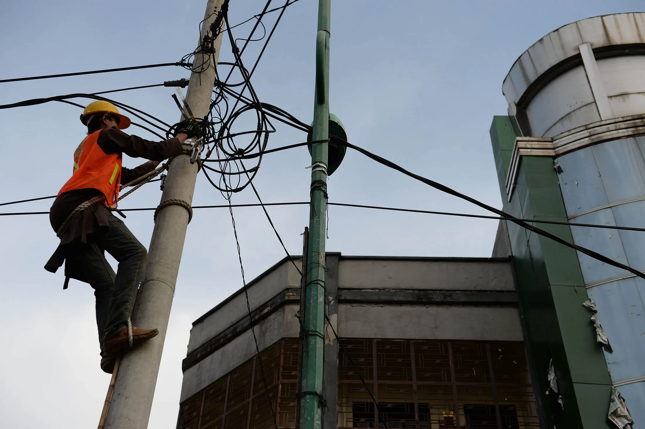 A PT Perusahaan Listrik Negara (PLN) technician performs maintenance work to power cables on a post in Medan, North Sumatra province, Indonesia, on Tuesday, April 7, 2015. For President Joko Widodo, a plan to build a $4 billion Japanese-Indonesian coal-fired power station presents a dilemma. He needs the electricity from new plants to power factories that would fuel growth and help rebalance the economy away from natural resources. At the same time, he needs to avoid alienating farmers and poor Indonesians who swept him into office last year.
