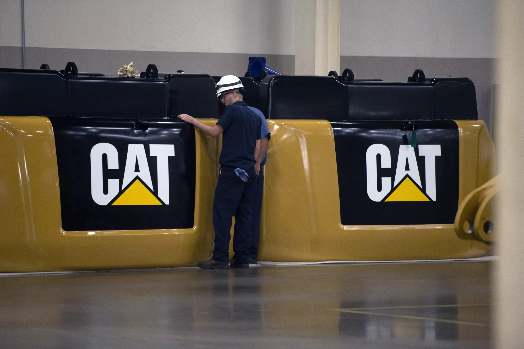 Employees inspect excavator components at the Caterpillar&nbsp;manufacturing facility in Victoria, Texas.