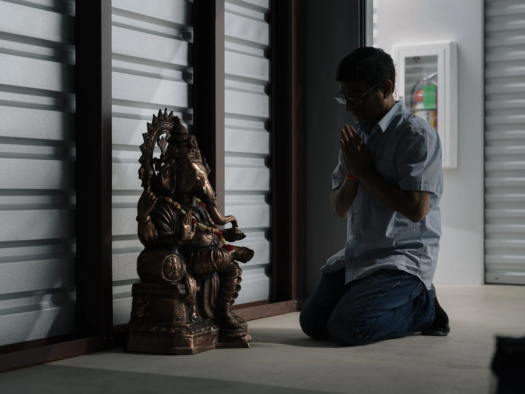 Ravi Vavilala prays inside his storage unit in McKinney, Texas.