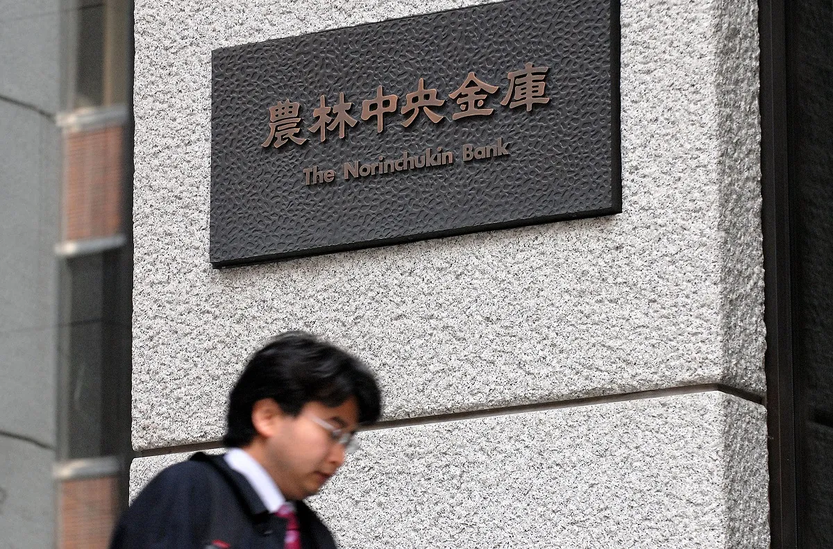 A businessman walks past the offices of the Norinchukin Bank in Tokyo on Friday, 6 April 2007.