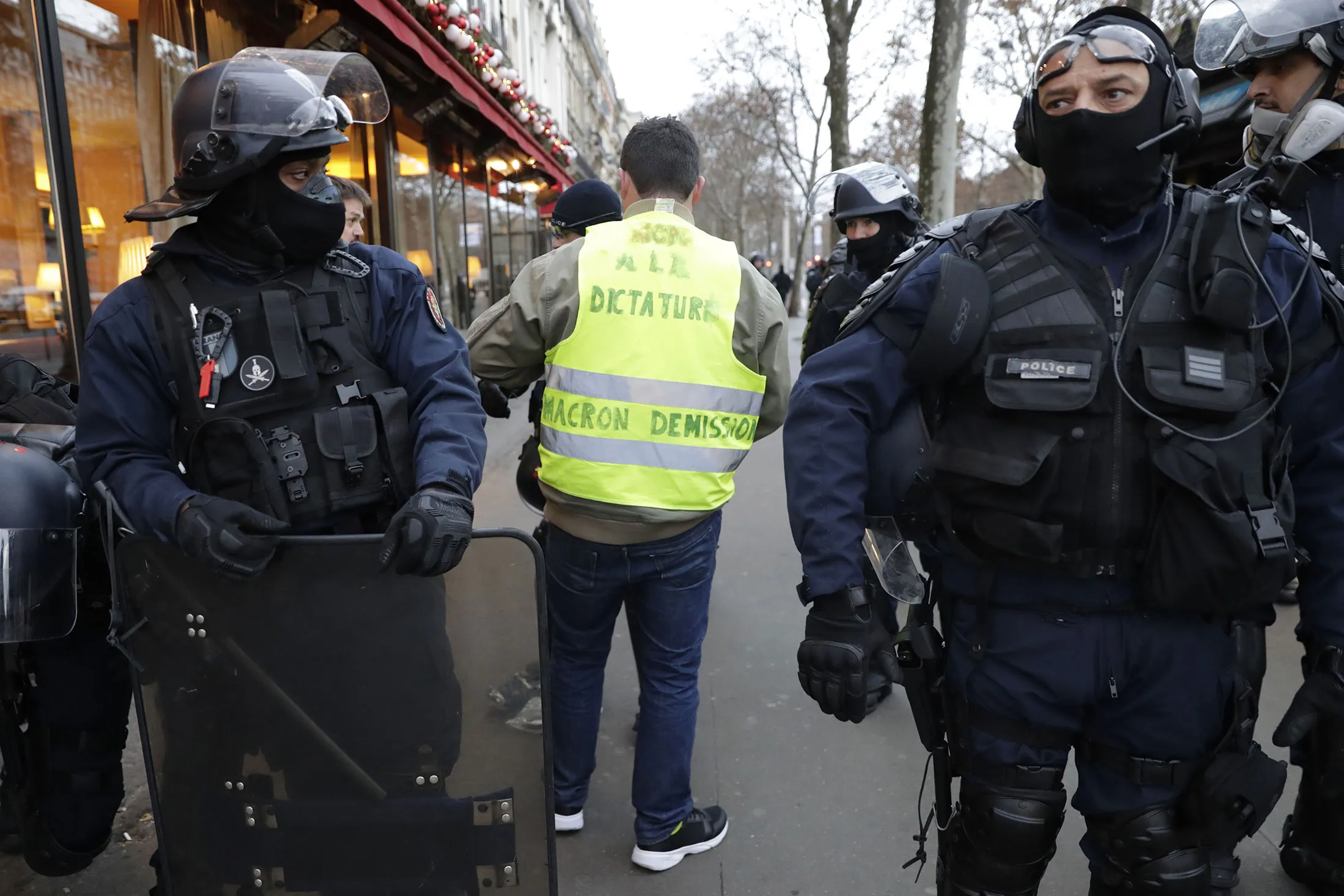 A yellow vest (Gilet jaune) protestor is searched by Riot police&nbsp;as he arrives near the Arc de Triomphe early on Dec&nbsp;8.&nbsp;