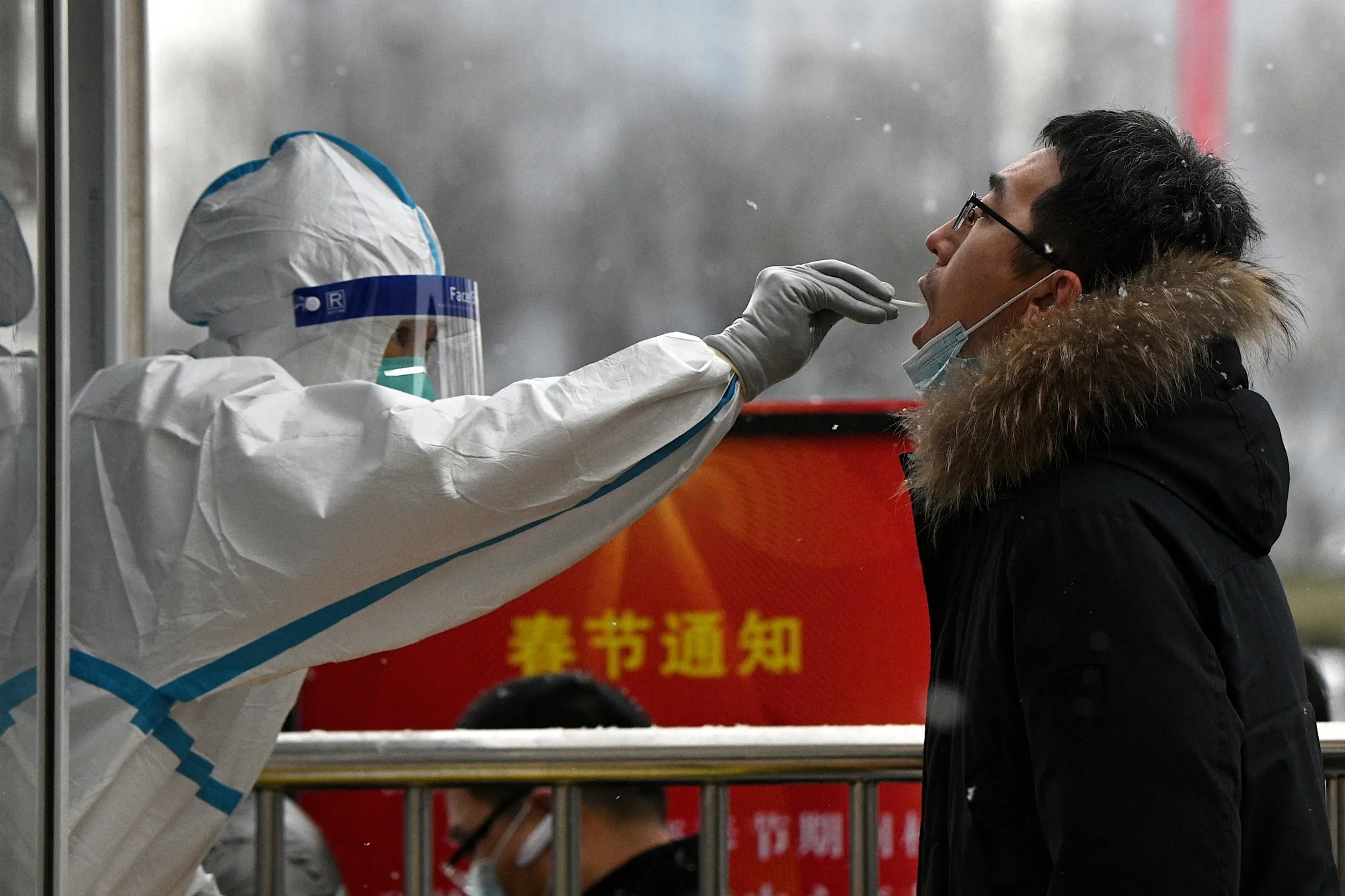 A health worker tests a man for&nbsp;Covid-19 in Beijing.
