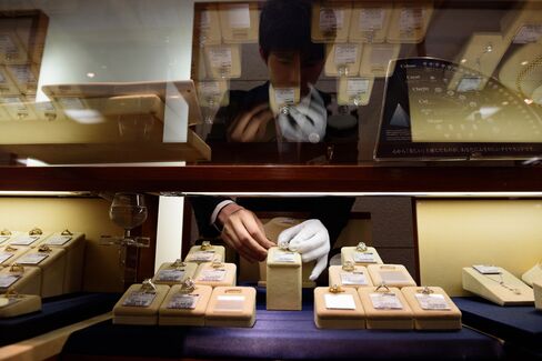 An employee arranges a used diamond ring inside the Komehyo Co. Shinjuku store in Tokyo. Photographer: Akio Kon/Bloomberg